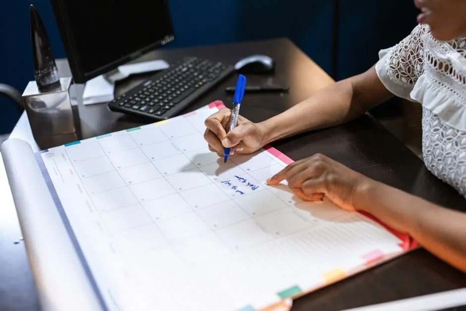 Người ghi chép kế hoạch trong ngày bên cạnh lịch bàn