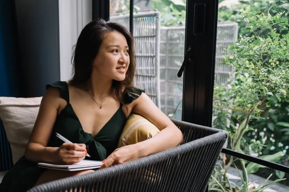 Người phụ nữ Việt ghi chép suy ngẫm bên cửa sổ tại nhà